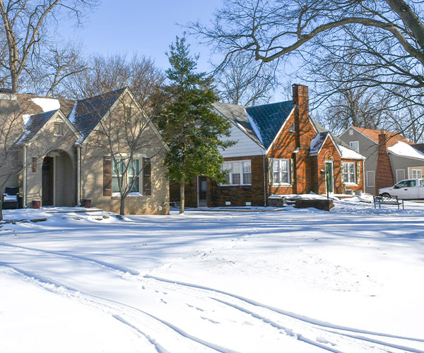 snow in yard with houses in background